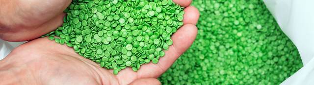 Hands holding biodegradable plastic pellets