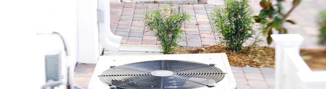 Row of air conditioning units on brick driveways.