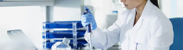 Scientist pipetting samples into tubes.