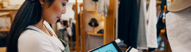 Retail shop clerk taking a mobile credit card payment on a digital tablet