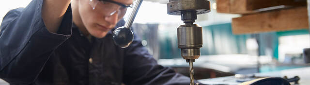 apprentice using pillar drill 