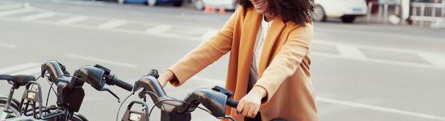 Woman in urban station with electric bicycles