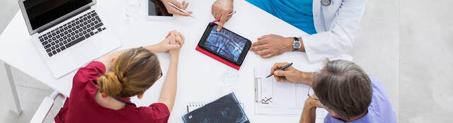 Medical team sitting and discussing at table.