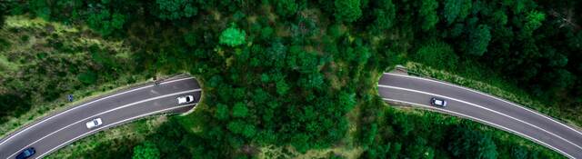 Aerial view of green bridge corridor for wildlife to cross highway safely.
