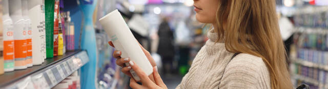 Person reading a label on a product while shopping in a store