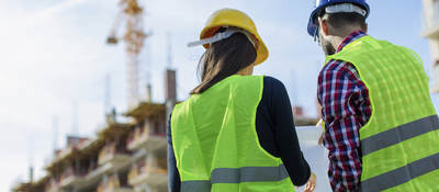 Two architects look at building.