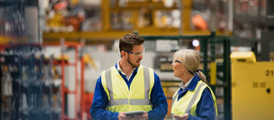 Workers collaborating in a warehouse with a tablet