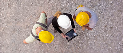 Workers on-site collaborating on a tablet