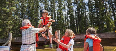 Family wearing personal flotation devices in a raft.