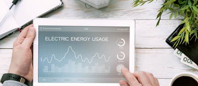Man holds tablet PC with electric energy usage application