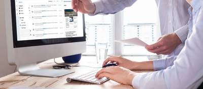 An office worker is being shown the new myUL portal on the computer.