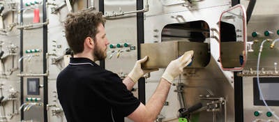 Man using a bank of small testing chambers to determine VOC emissions from products.