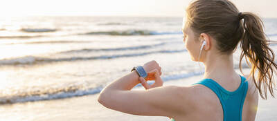 woman working out, looking at smartwatch