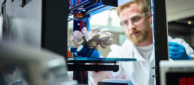 Photo of a scientist testing 3D printed plastic object