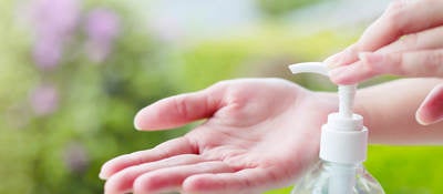 Female hand dispensing hand sanitizer onto open palm