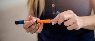woman holding insulin injector pen