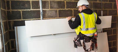 Construction worker using drywall