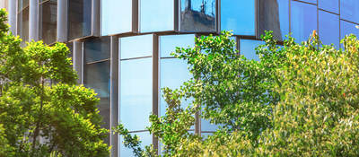 glass building  with trees in front of it