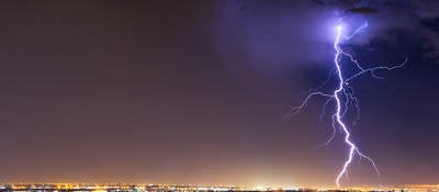 lightning striking cityscape at night 