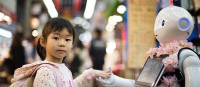 Asian girl touching robot's hand