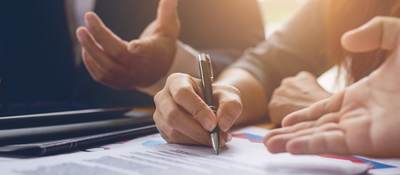 Photo of a person signing a contract