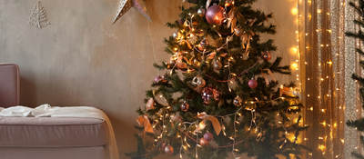 A living room with pre-lit Christmas tree and other lit decorations