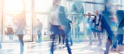 Business people walking in the lobby of a building with glass windows
