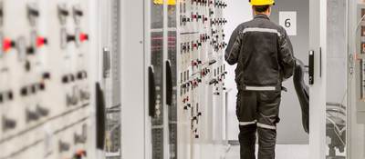 Engineer using protective relay and medium voltage switchgear in a bay control unit.