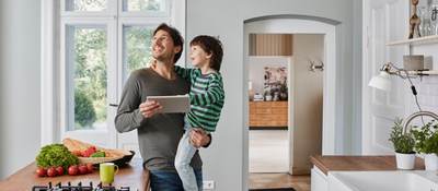 Father and son switching on smart lighting in the kitchen