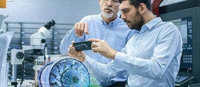 two male laboratory technicians observing a digital model