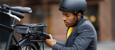 Young man changing battery pack on electric bicycle