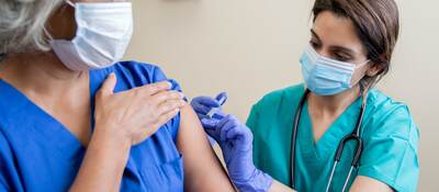 Nurse provides vaccine to elderly woman