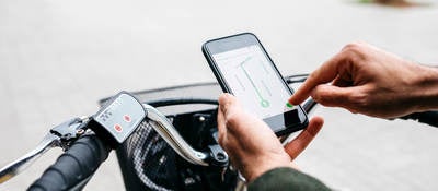 Man with e-bike using a smartphone for navigation