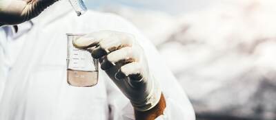 Person in protective suit examining polluted water