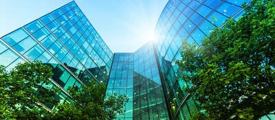 Low angle view of multi-story glass front modern office building