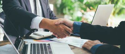 Business people shaking hands across a desk