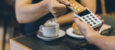 man paying with a credit card in cafe