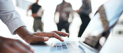 man typing on laptop keyboard