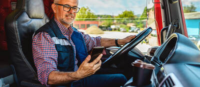 man looking at a mobile phone in the truck