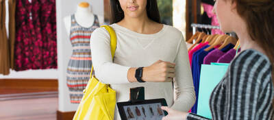 woman paying with smartwatch in store