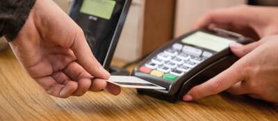 man inserting a credit card into a payment terminal