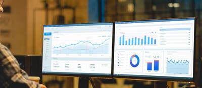 two monitors showing graphs and data