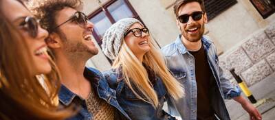 Men and women wearing different types of eyewear walking down a city street