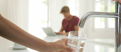 Person filling a glass with water