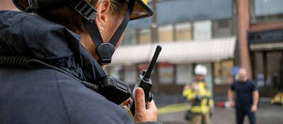 Firefighter with a radio device outside of a building