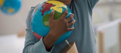 Child holding a toy ball.