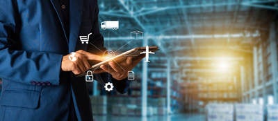 Man holding mobile device with inside factory
