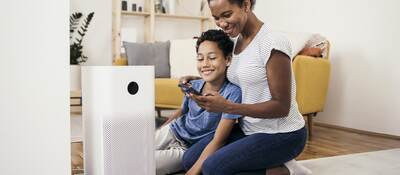 African American woman and her son setting up the intelligent home system on a smartphone.