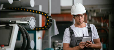 Worker in hardhat working with a tablet