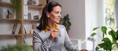 Person in home office setting, with a cup of coffee